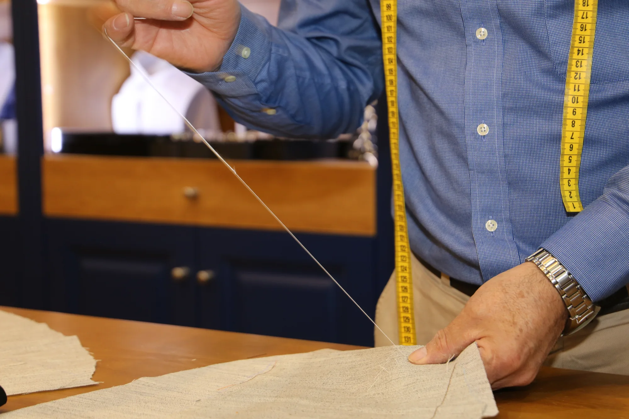 Thread drawn by hand through canvas, tape measure around the neck