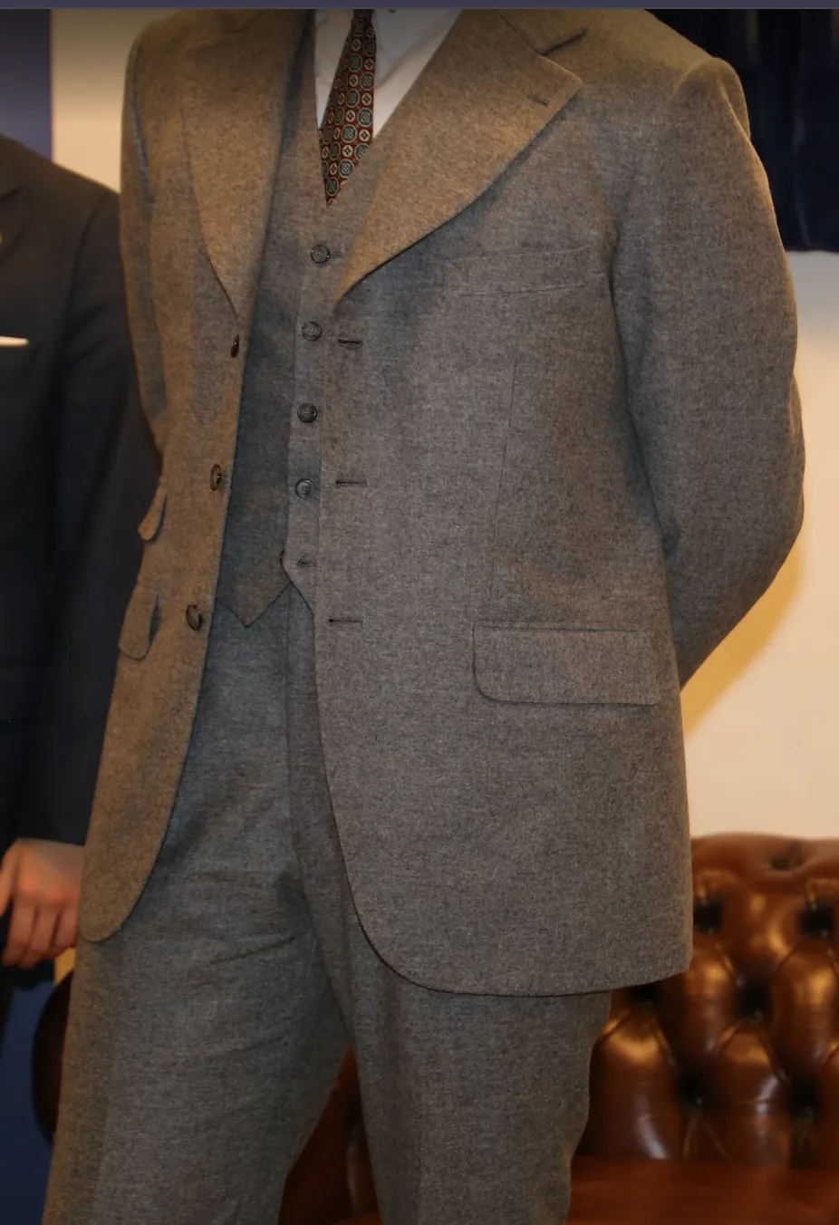 Traje de tres piezas en franela gris, con chaqueta, chaleco y pantalón, sobre maniquí